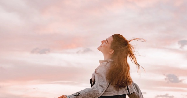 空に向かって目を閉じている女性